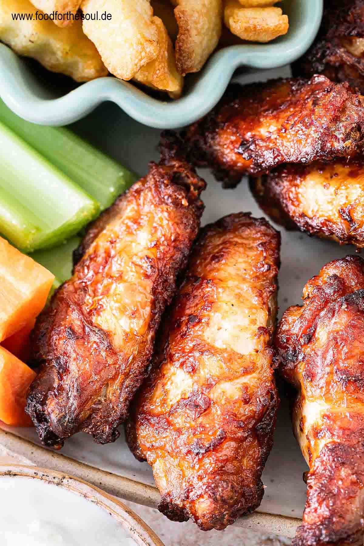 Im Airfryer frittierte TK Chicken Wings angerichetet mit Dip, Pommes, Sellerie und Karotten