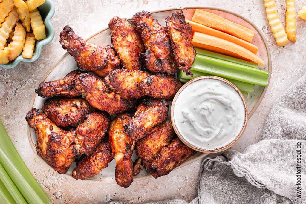 Im Airfryer frittierte TK Chicken Wings angerichetet mit Dip, Sellerie und Karotten