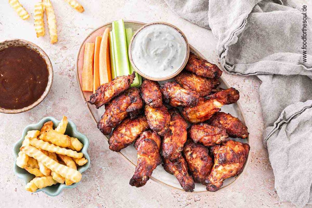 Im Airfryer frittierte TK Chicken Wings angerichetet mit Dip, Sellerie und Karotten