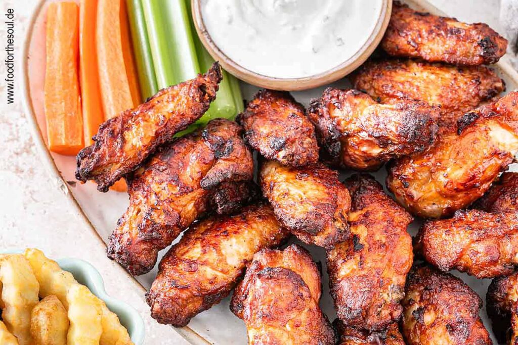 Im Airfryer frittierte TK Chicken Wings angerichetet mit Dip, Sellerie und Karotten