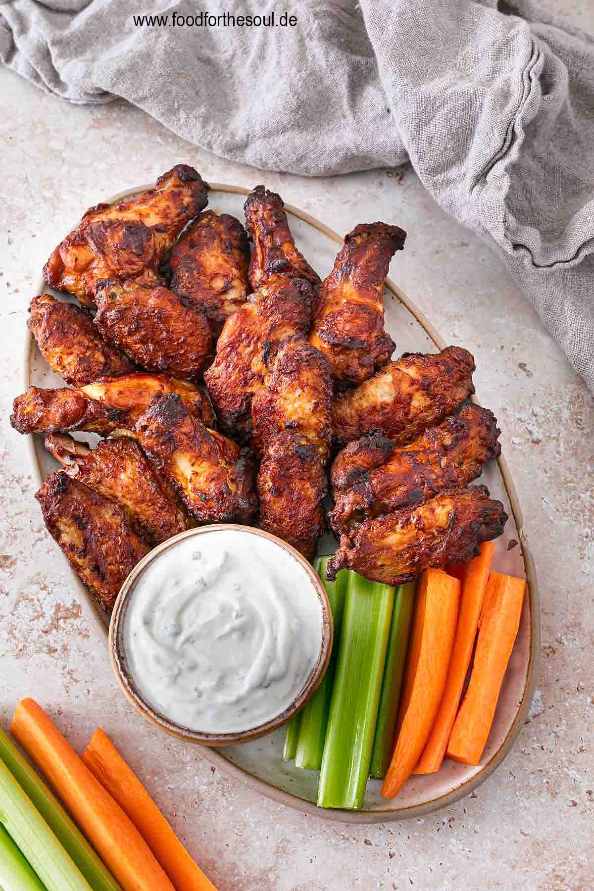 Im Airfryer frittierte TK Chicken Wings angerichetet mit Dip, Sellerie und Karotten