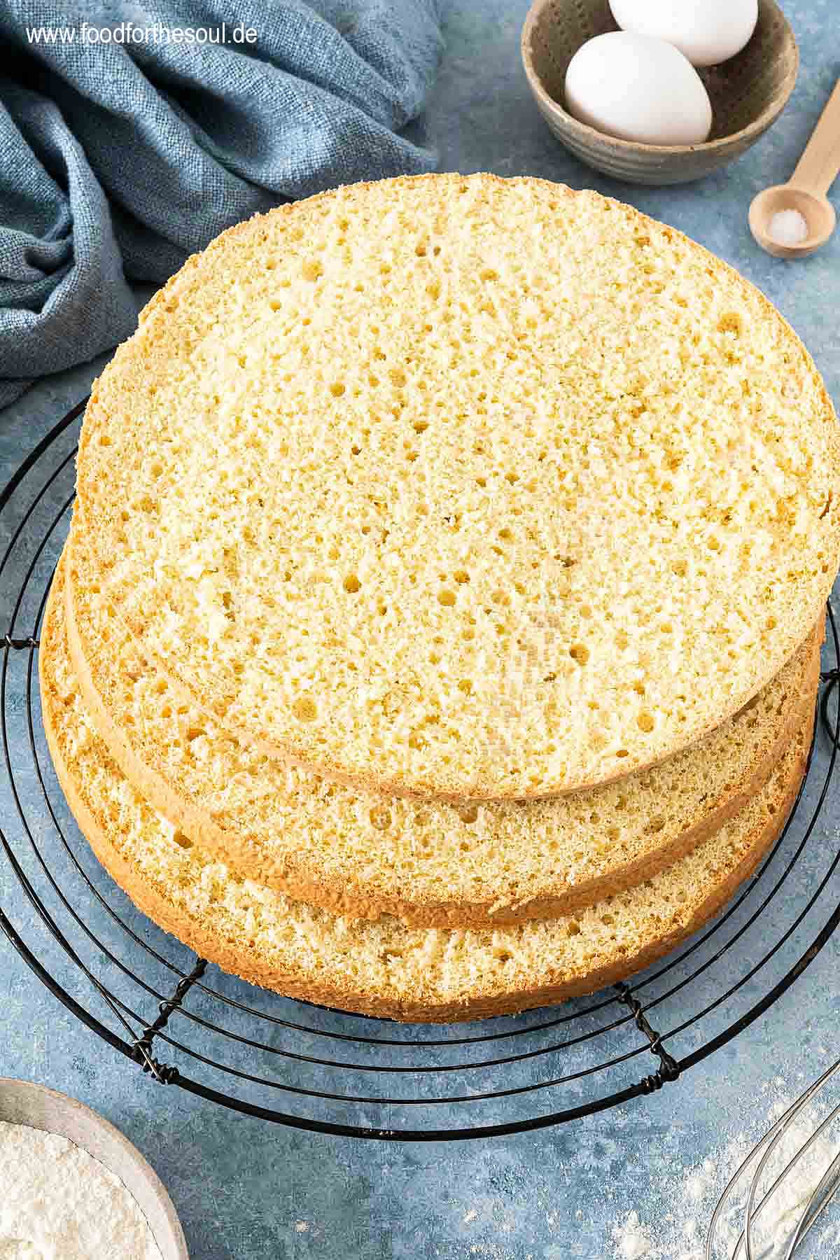 In drei Teile geschnittener Biskuitboden auf einem Auskühlgitter