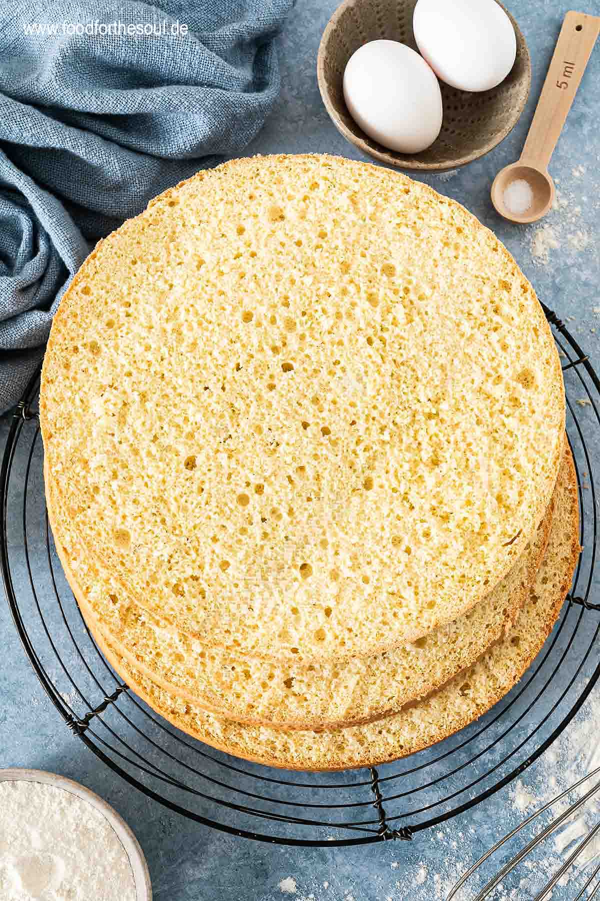 In drei Teile geschnittener Biskuitboden auf einem Auskühlgitter