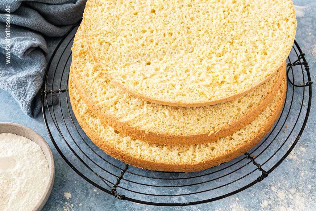 In drei Teile geschnittener Biskuitboden auf einem Auskühlgitter