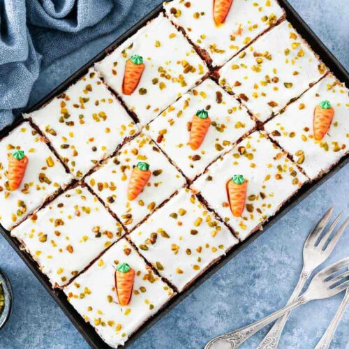 Karottenkuchen dekoriert mit Marzipan-Möhren und gehackten Pistazien