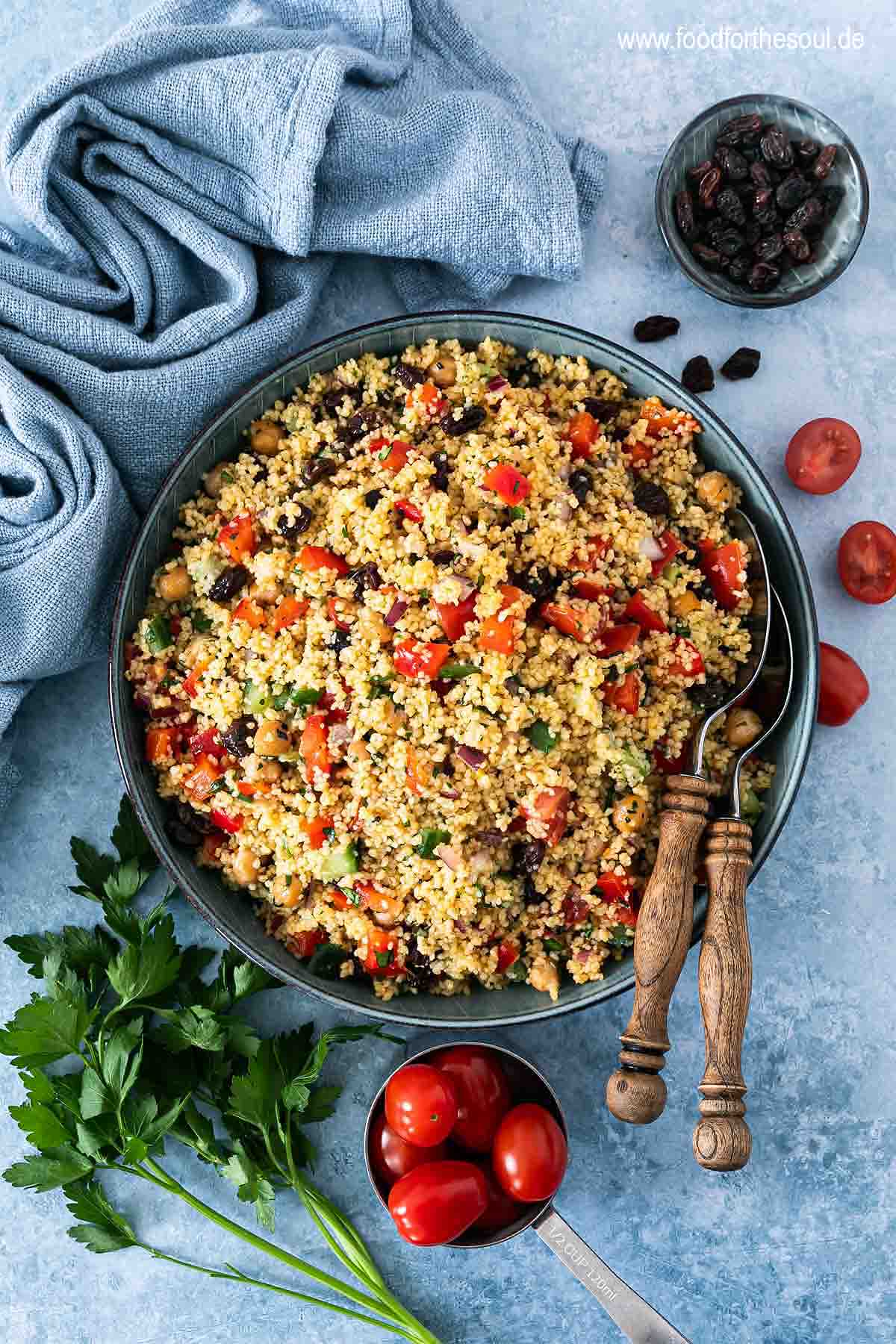Frisch zubereiteter Couscous Salat in einer Schale mit Salatlöffeln