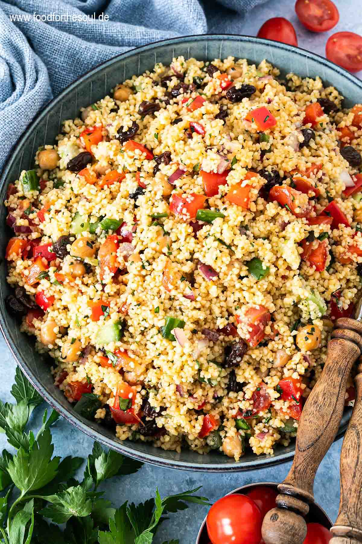 Frisch zubereiteter Couscous Salat in einer Schale mit Salatlöffeln