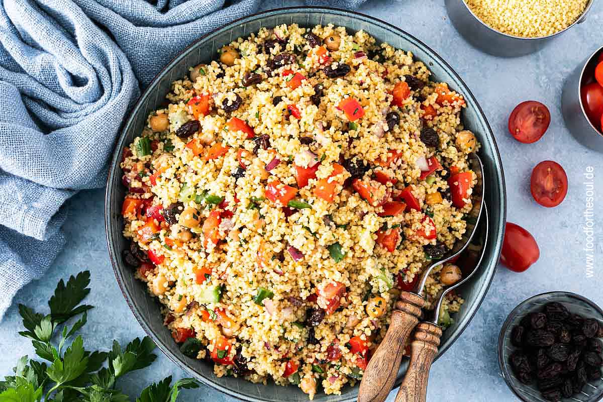 Frisch zubereiteter Couscous Salat in einer Schale mit Salatlöffeln