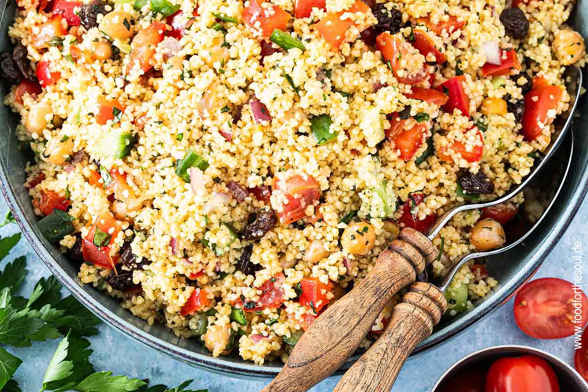Frisch zubereiteter Couscous Salat in einer Schale mit Salatlöffeln