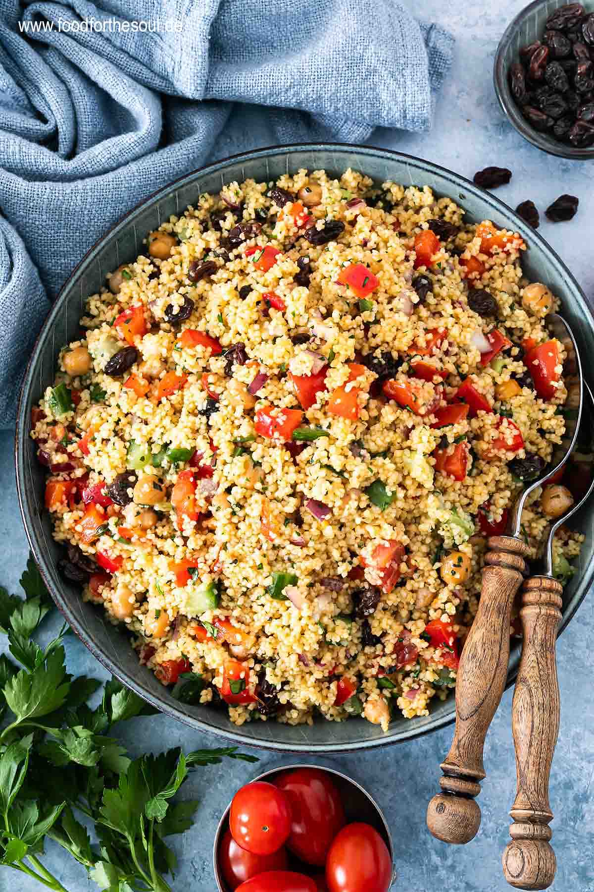 Frisch zubereiteter Couscous Salat in einer Schale mit Salatlöffeln