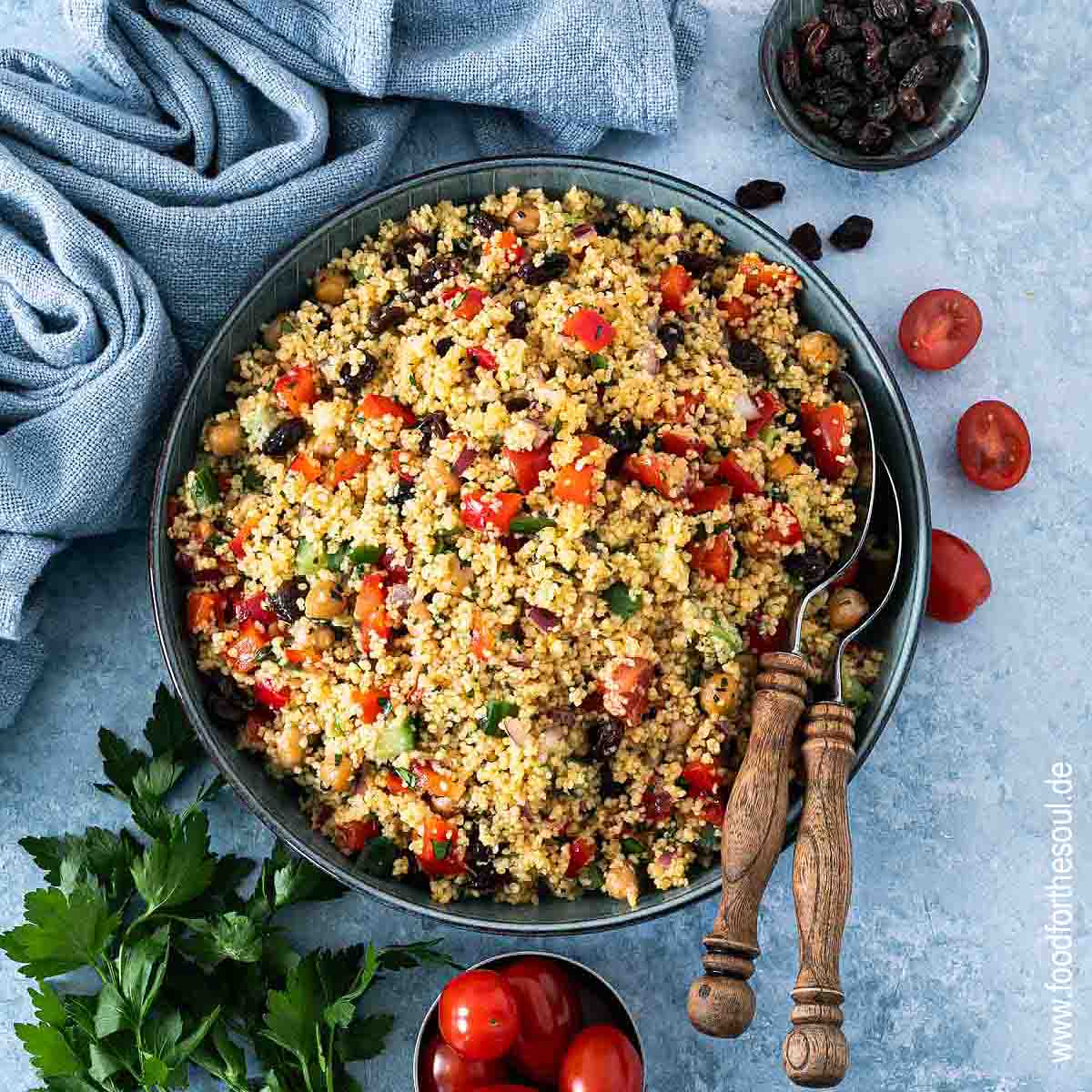 Frisch zubereiteter Couscous Salat in einer Schale mit Salatlöffeln
