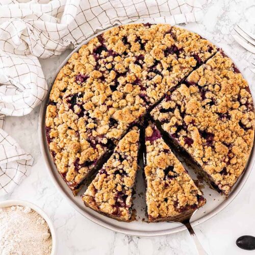 Traubenkuchen mit Streusel auf einem Teller mit Tortenheber