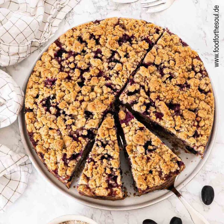 Traubenkuchen mit Streusel auf einem Teller mit Tortenheber