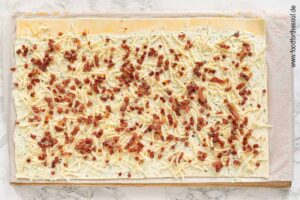 Schinkenspeck über den geriebenen Käse streuen - Schritt 5