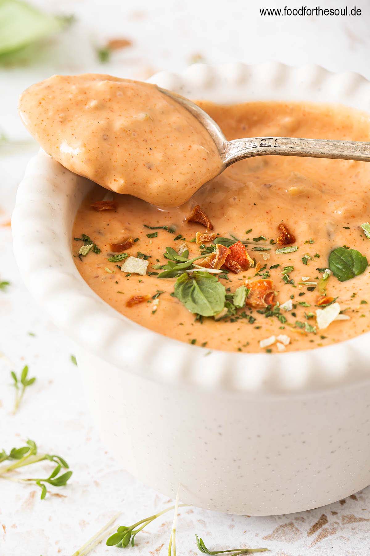 Burger Sauce in einer Schale und auf einem Löffel, garniert mit Kräutern