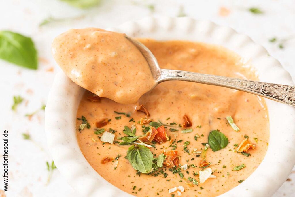 Burger Sauce in einer Schale und auf einem Löffel, garniert mit Kräutern