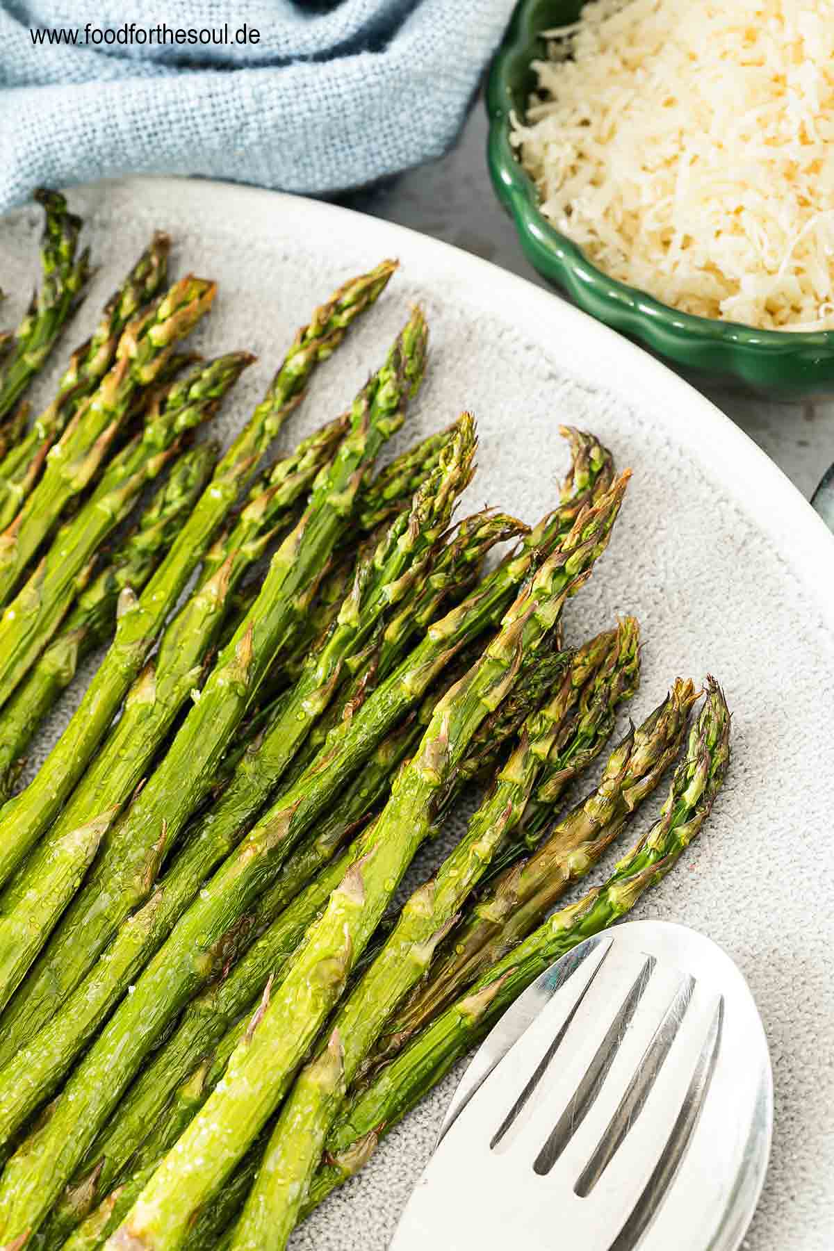 Grüner Spargel aus dem Airfryer angerichtet auf einer Servierplatte