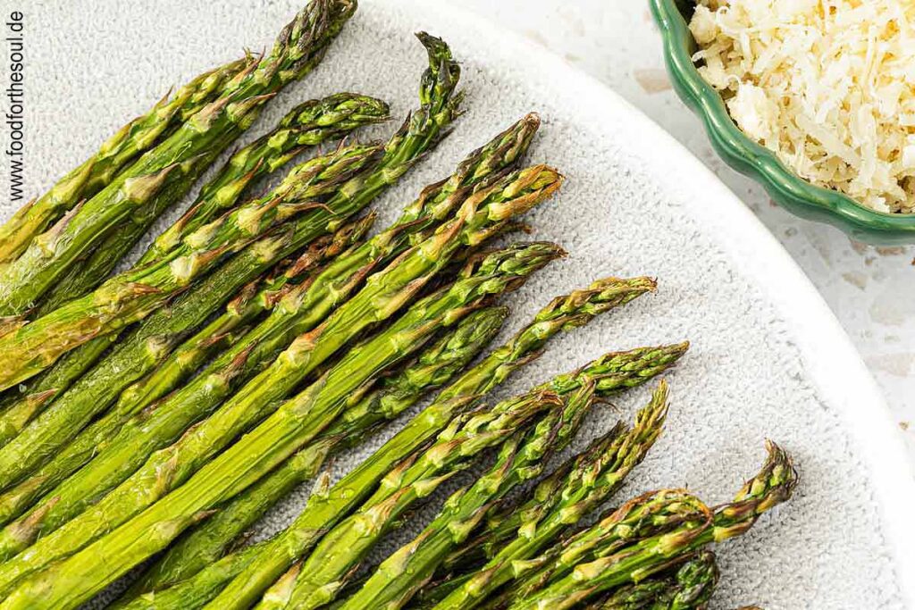 Grüner Spargel aus dem Airfryer angerichtet auf einer Servierplatte