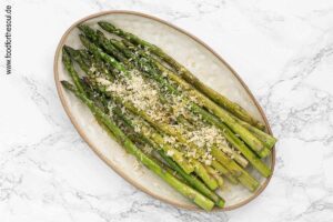 Gerösteten Knoblauch in Olivenöl und Parmesan über gebratenen grünen Spargel geben - Schritt 6