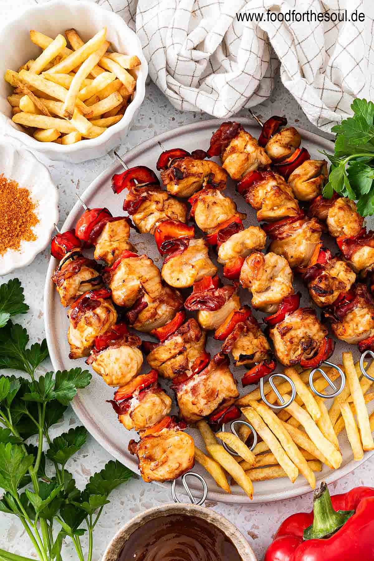 Hähnchen Schaschlik Spieße angerichtet mit Pommes auf einem Teller