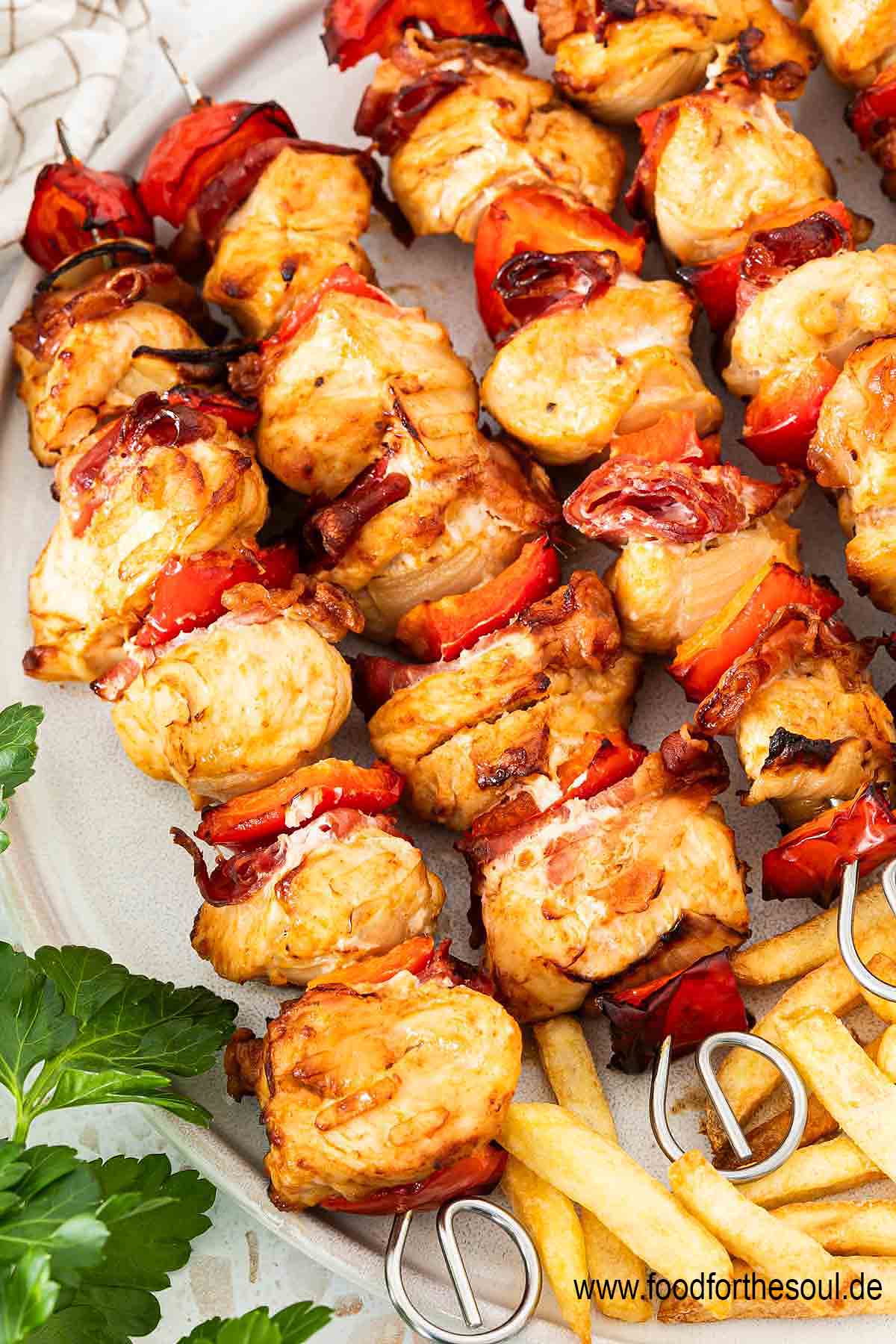 Hähnchen Schaschlik Spieße angerichtet mit Pommes auf einem Teller