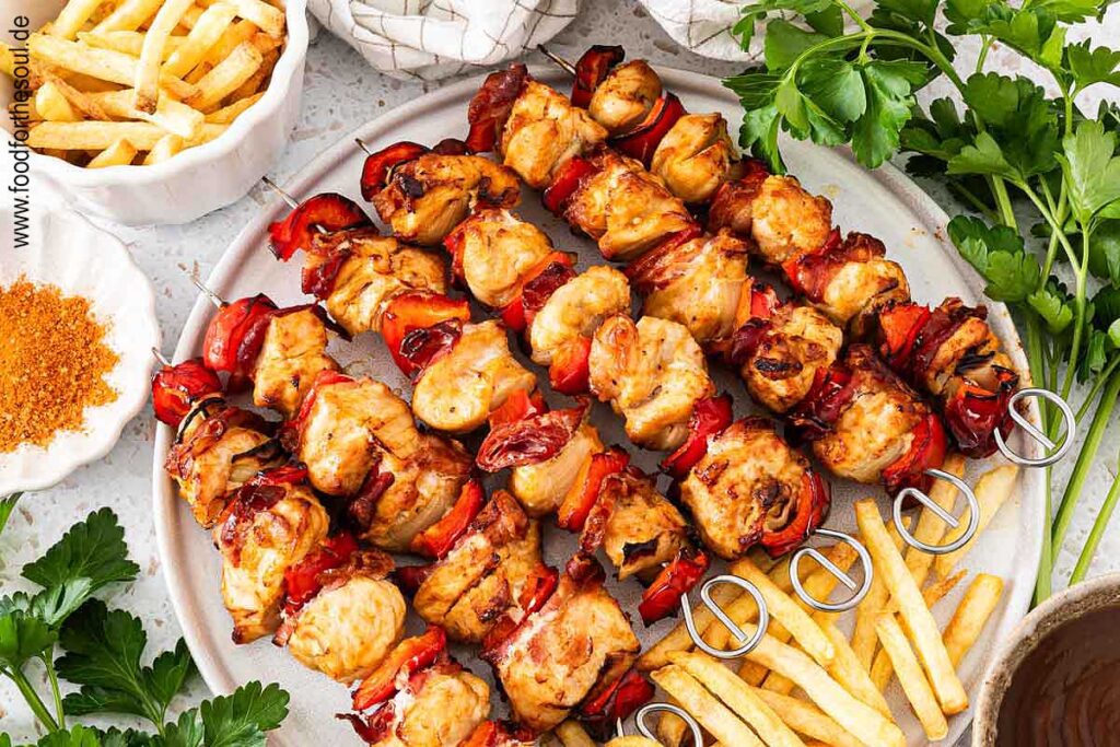 Hähnchen Schaschlik Spieße angerichtet mit Pommes auf einem Teller