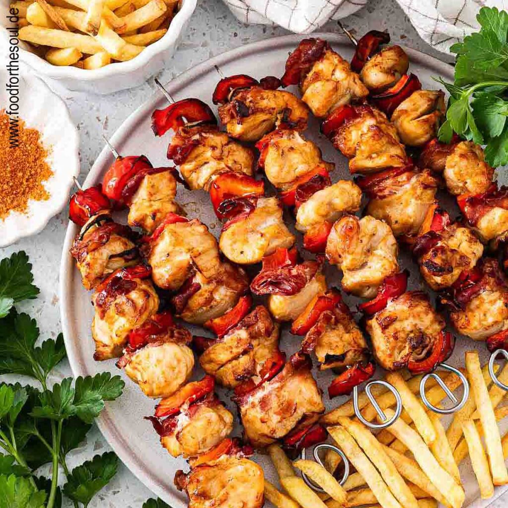Hähnchen Schaschlik Spieße angerichtet mit Pommes auf einem Teller