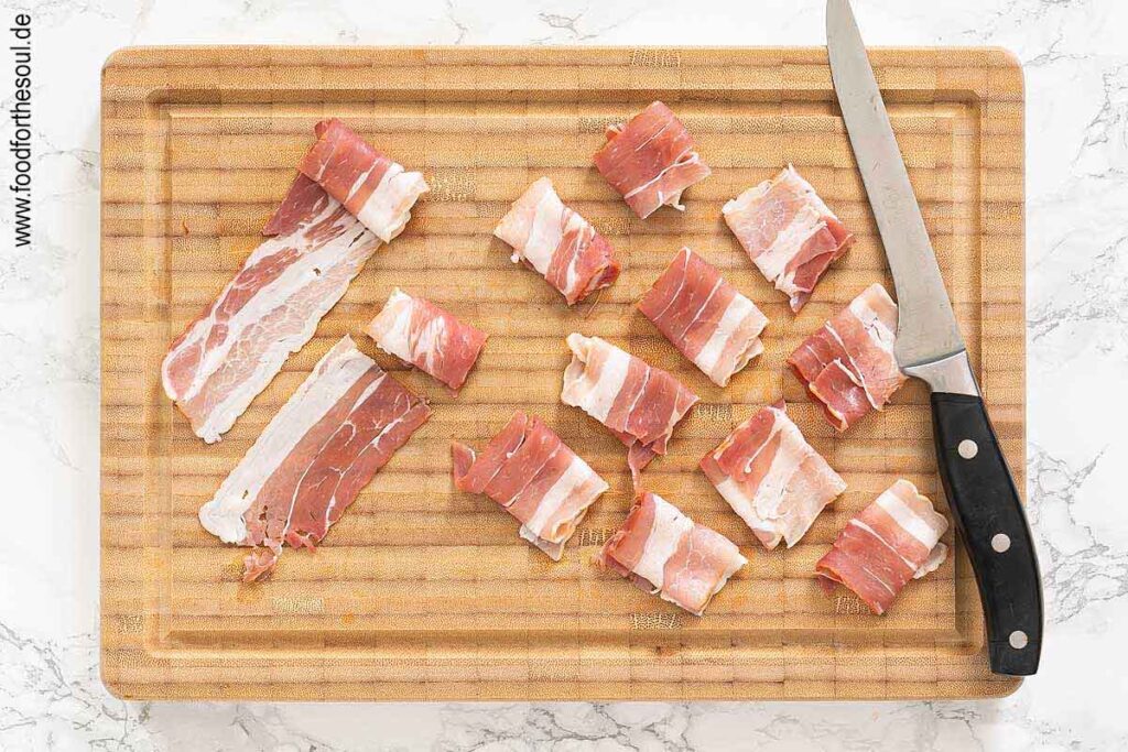 Bacon Scheiben bis zur Hälfte aufrollen und durchschneiden - Schritt 3