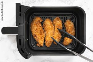 Airfryer einstellen, starten und Hähnchenstreifen nach der Hälfte der Garzeit mit einer Zange wenden - Schritt 6