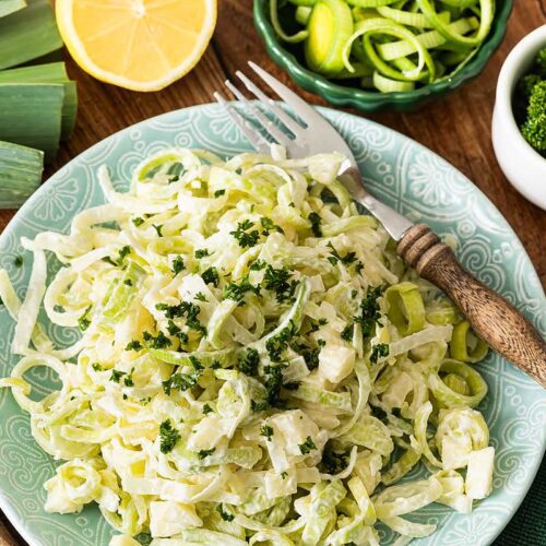 Porreesalat mit Apfel angerichtet auf einem Teller und mit Petersilie garniert