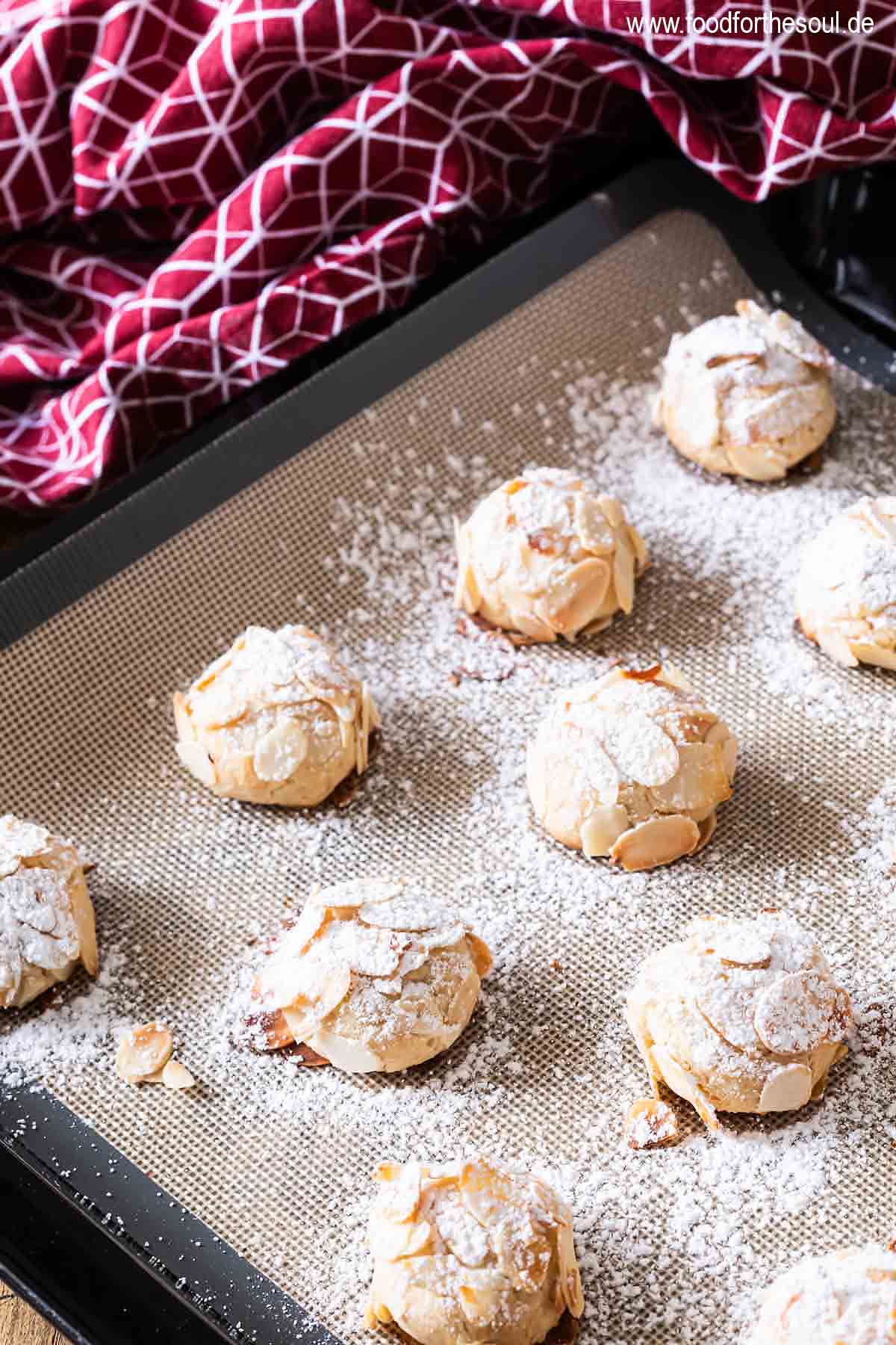 Mandorlinis mit Puderzucker bestäubt auf einem Backblech
