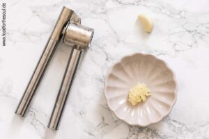 Knoblauch durch eine Knoblauchpresse drücken - Schritt 1