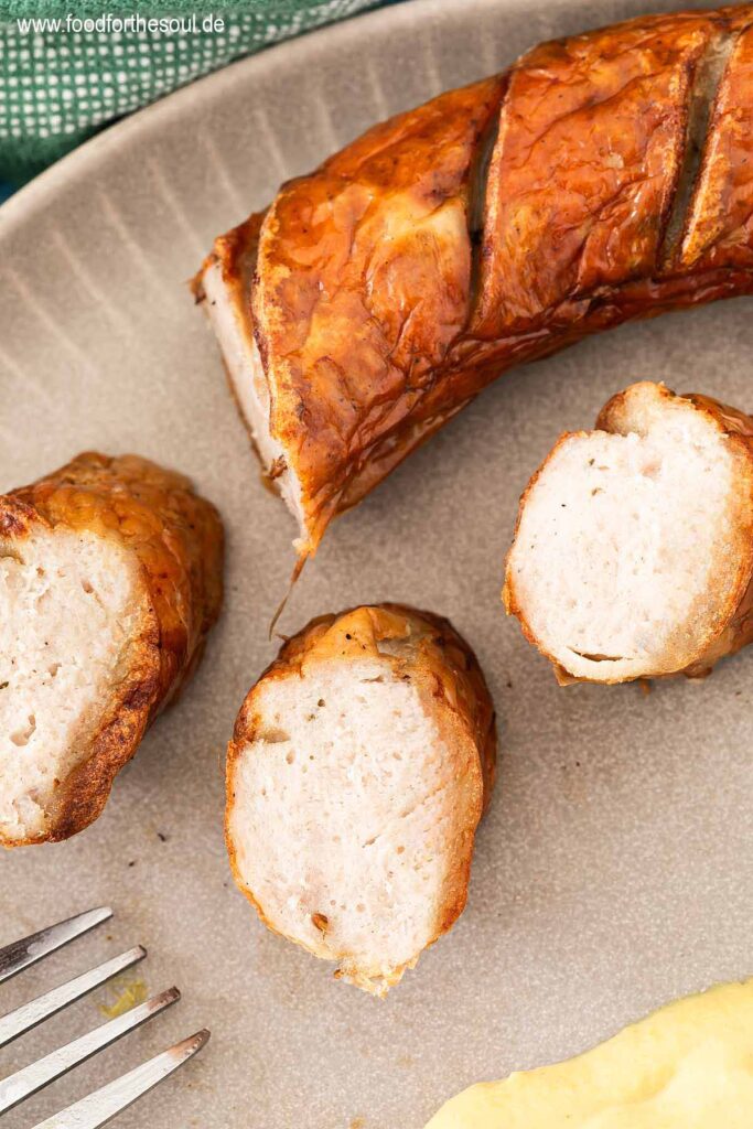 Bratwurst aus der Heißluftfritteuse angeschnitten auf einem Teller