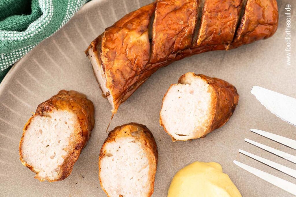 Bratwurst aus der Heißluftfritteuse angeschnitten auf einem Teller