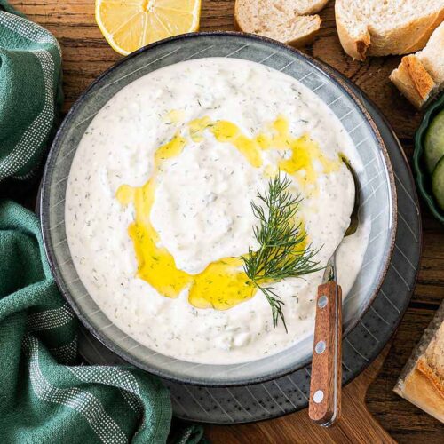 Tzatziki in einer Schale mit Olivenöl und Dill garniert