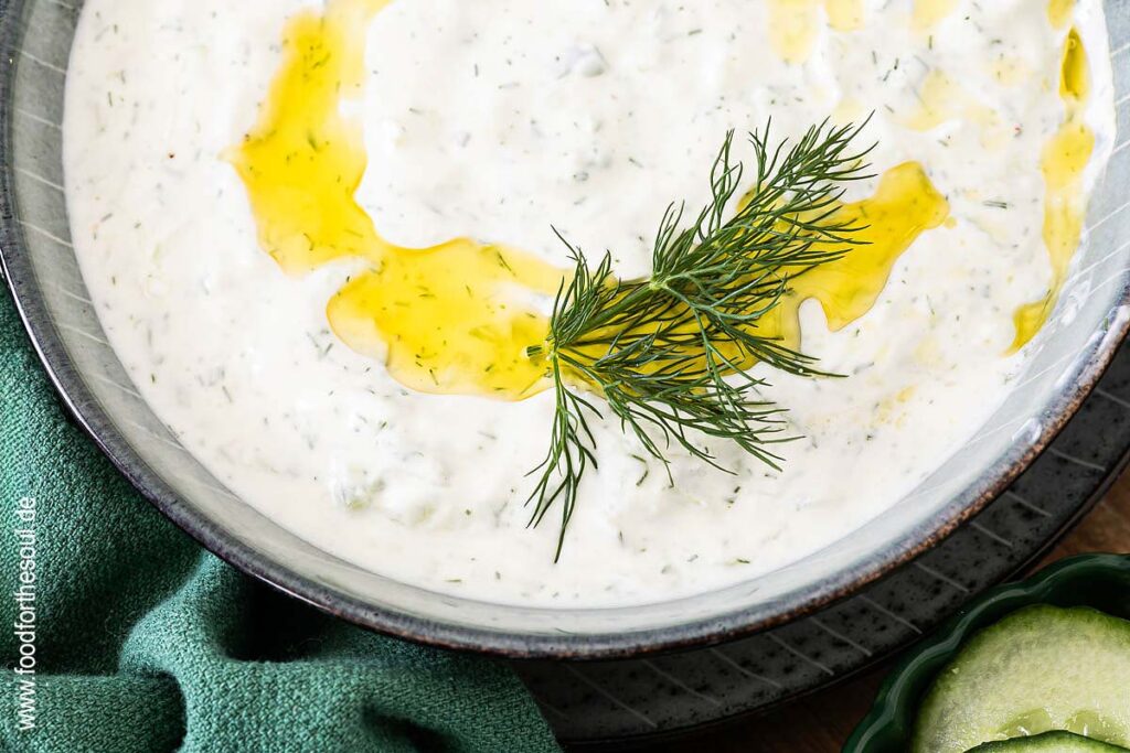 Tzatziki in einer Schale mit Olivenöl und Dill garniert