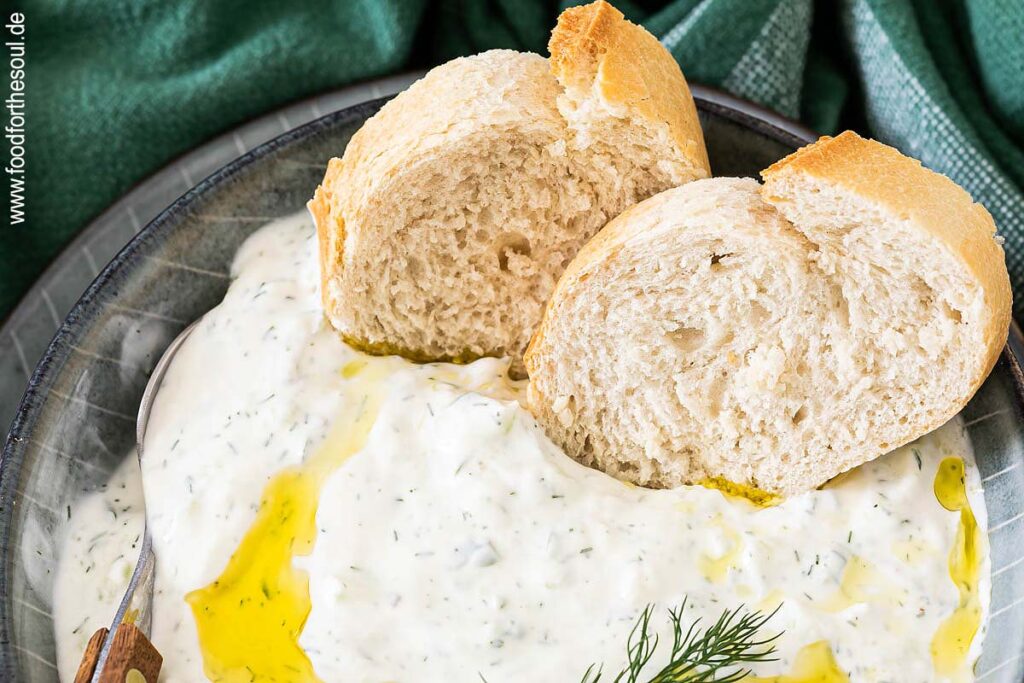 Tzatziki in einer Schale mit Olivenöl und Baguette Scheiben