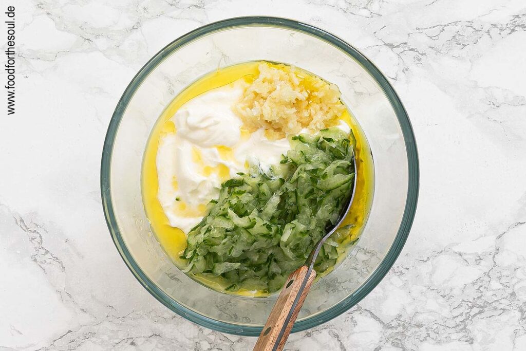 Joghurt mit Olivenöl, Knoblauch, Zitronensaft und geraspelter Gurke verrühren - Schritt 5