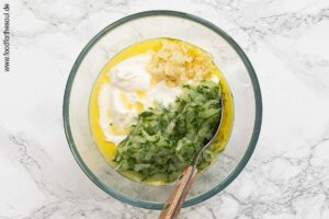 Joghurt mit Olivenöl, Knoblauch, Zitronensaft und geraspelter Gurke verrühren - Schritt 5