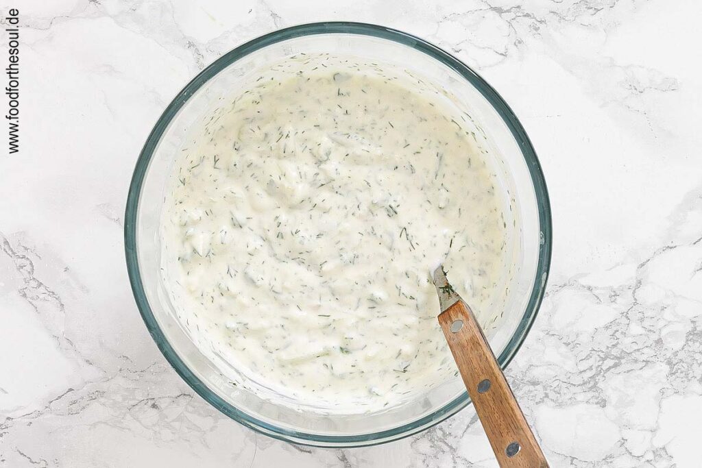 Dill unter Tzatziki rühren und mit Salz und Pfeffer abschmecken - Schritt 7