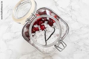 Kirschen mit Kandiszucker und Vanilleschote in großen Glasbehälte füllen - Schritt 2