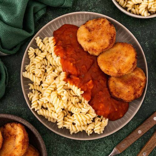 Jägerschnitzel nach DDR Art mit Tomatensoße und Nudeln auf einem Teller