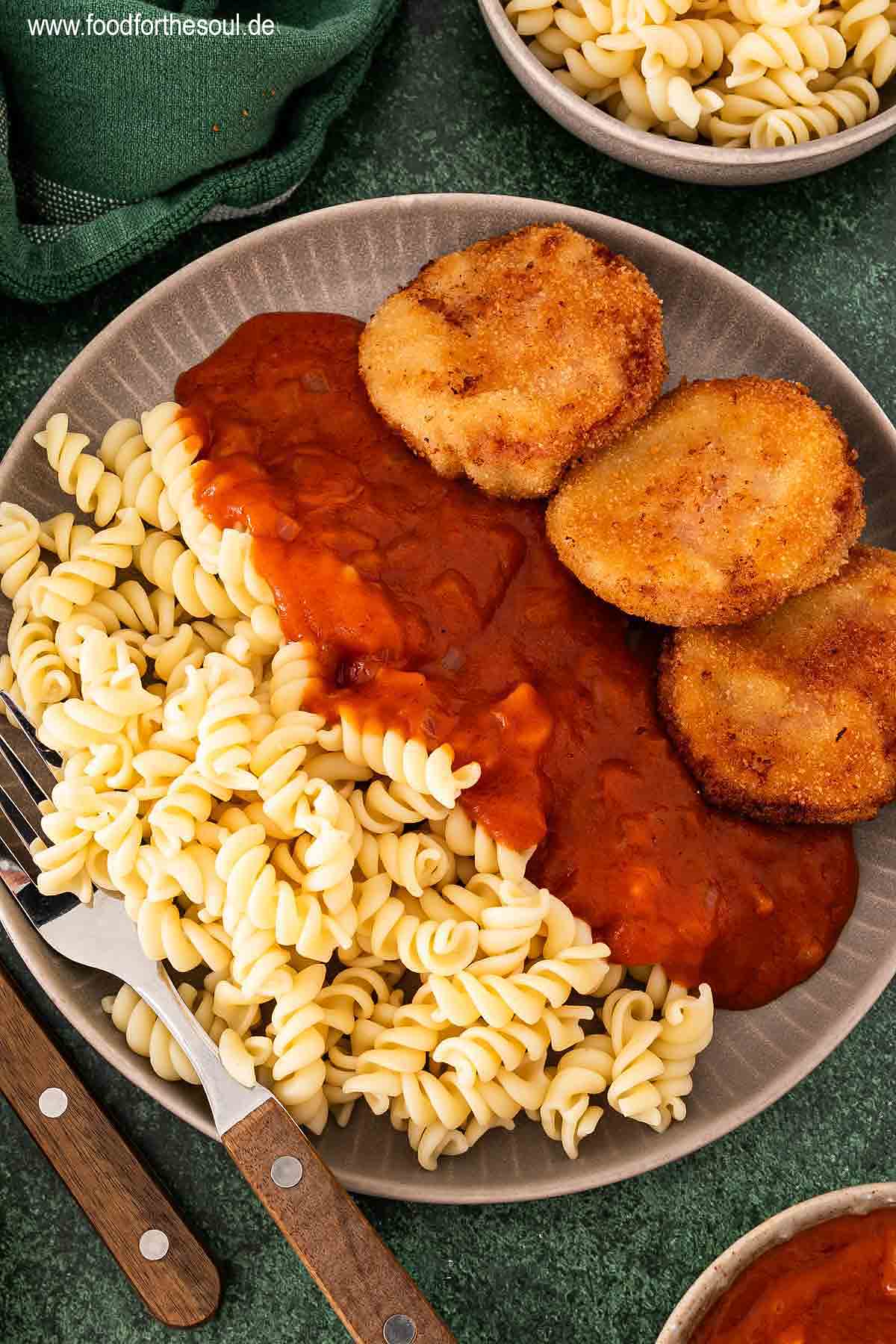 Jägerschnitzel nach DDR Art mit Tomatensoße und Nudeln auf einem Teller