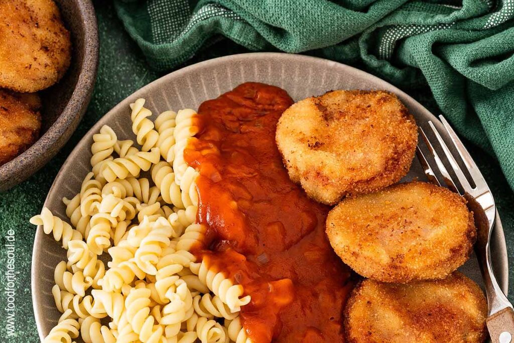 Jägerschnitzel nach DDR Art mit Tomatensoße und Nudeln auf einem Teller