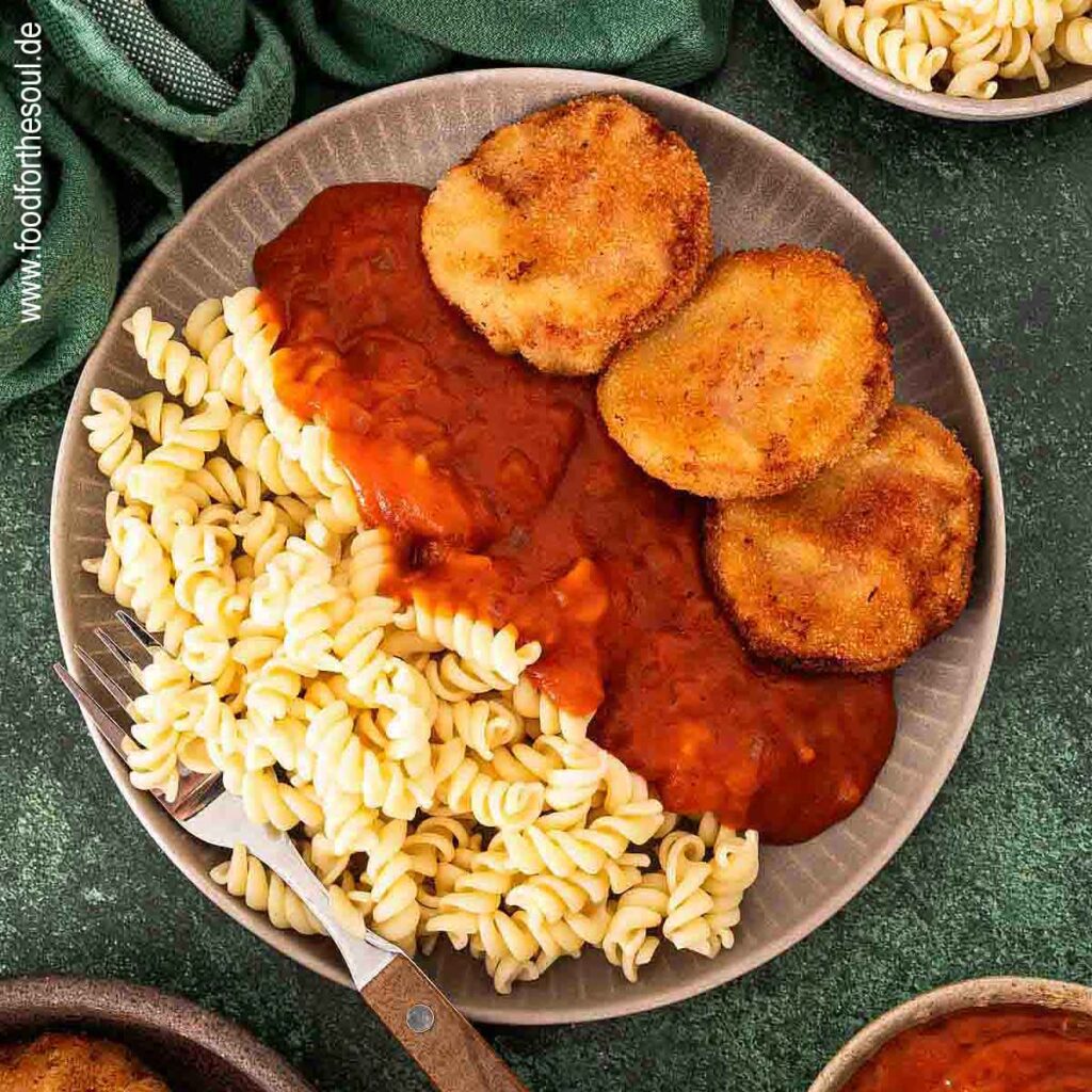 Jägerschnitzel nach DDR Art mit Tomatensoße und Nudeln auf einem Teller