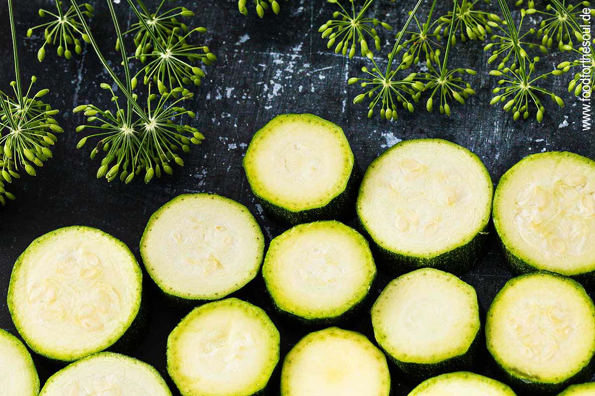 Zucchini-Scheiben und Dillblüten