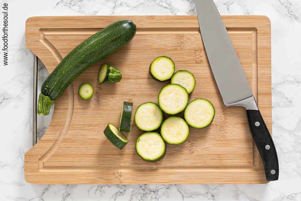 Zucchini waschen, Enden entfernen und in Scheiben schneiden - Schritt 1