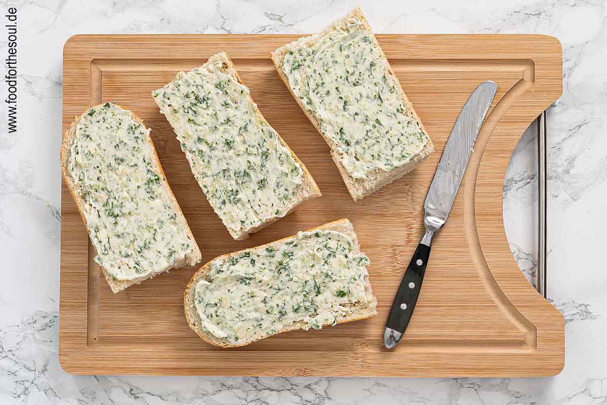 Baguette halbieren und vierteln, mit Knoblauchbutter bestreichen - Schritt 4