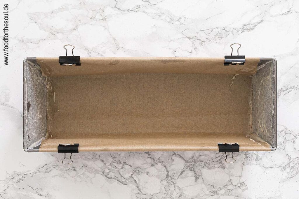 Kastenform mit Backpapier auskleiden und die Seiten einfetten und bemehlen