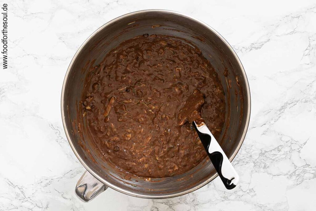 Geraspelte Zucchini und Schokotröpfchen unter den Schokoteig heben - Schritt 6